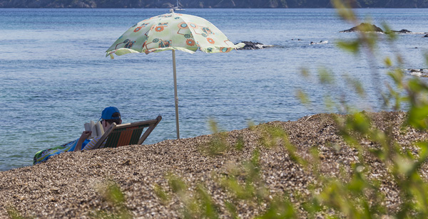 spiaggia di Norsi all'isola d'Elba turista sotto l'ombrellone che legge