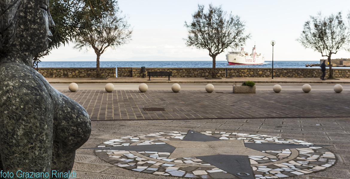 piazza con statua di olivina con nave Toremar