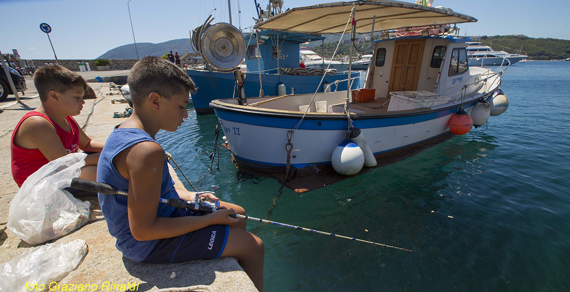 Porto Azzurro Isola d'Elba - bambini che pescano sul porto
